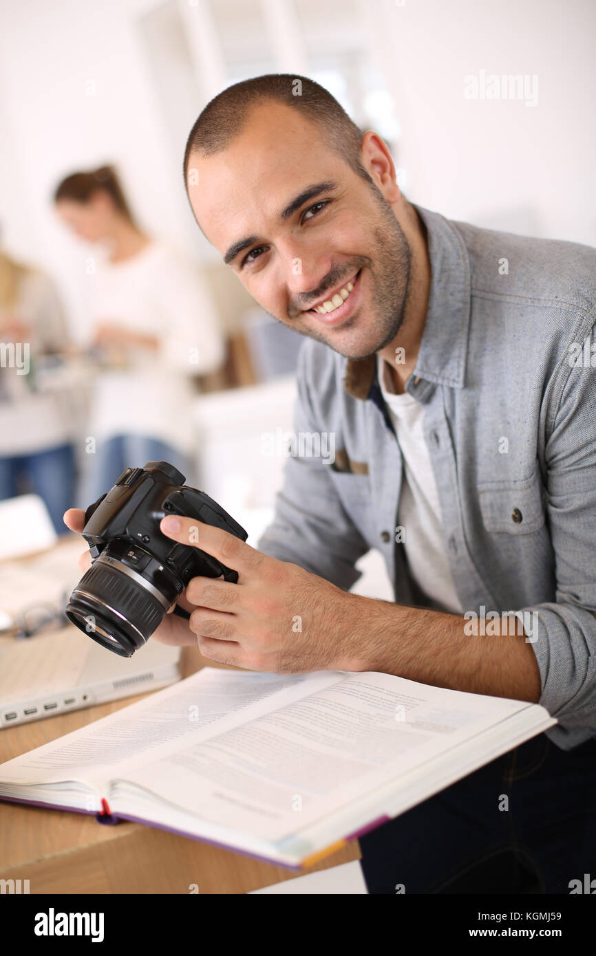 Cheerful reporter working in office on laptop Stock Photo - Alamy