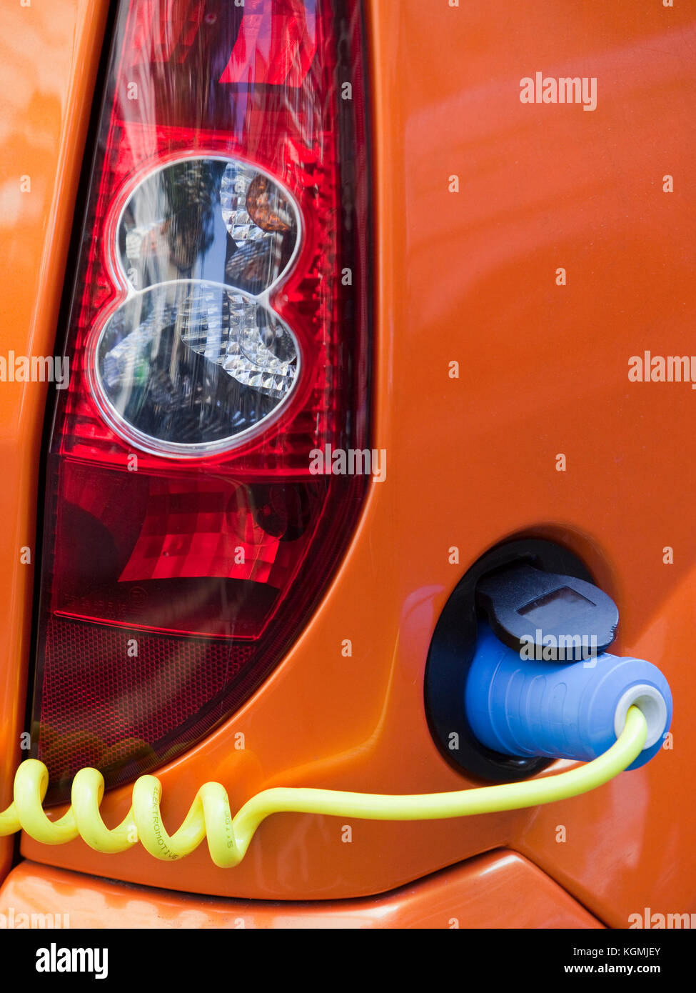 Electric car connected to a charger via a cable Stock Photo