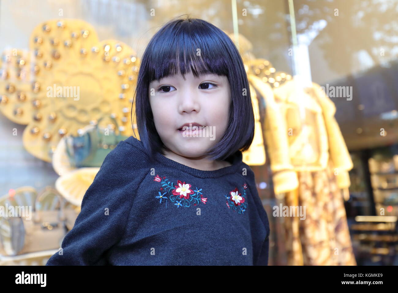 Little Girl in Front of a Window Shop in Close Up.  Model Release OK Stock Photo