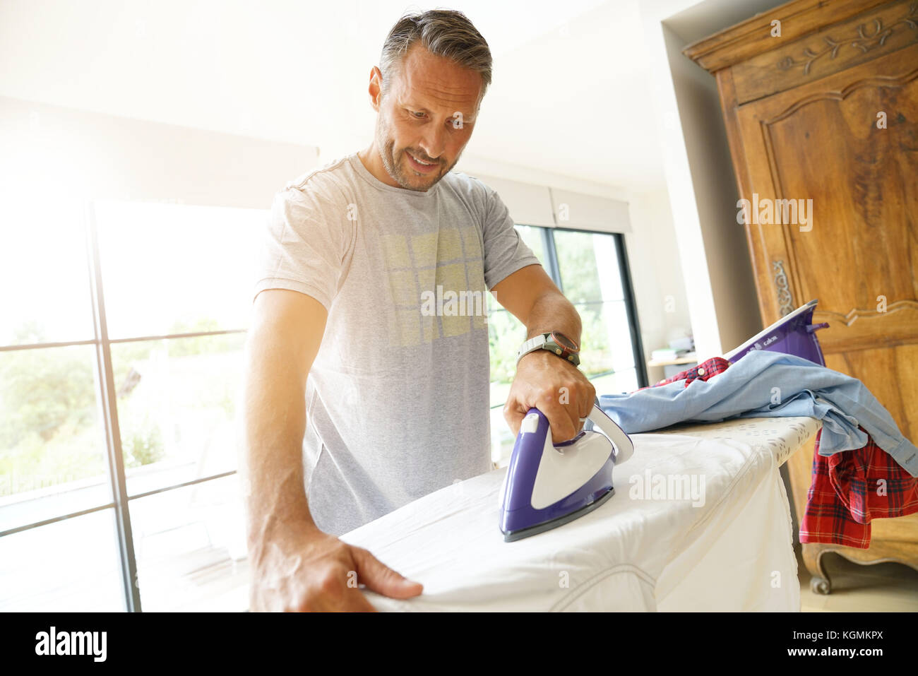 Man At Home Ironing Clothes Stock Photo Alamy
