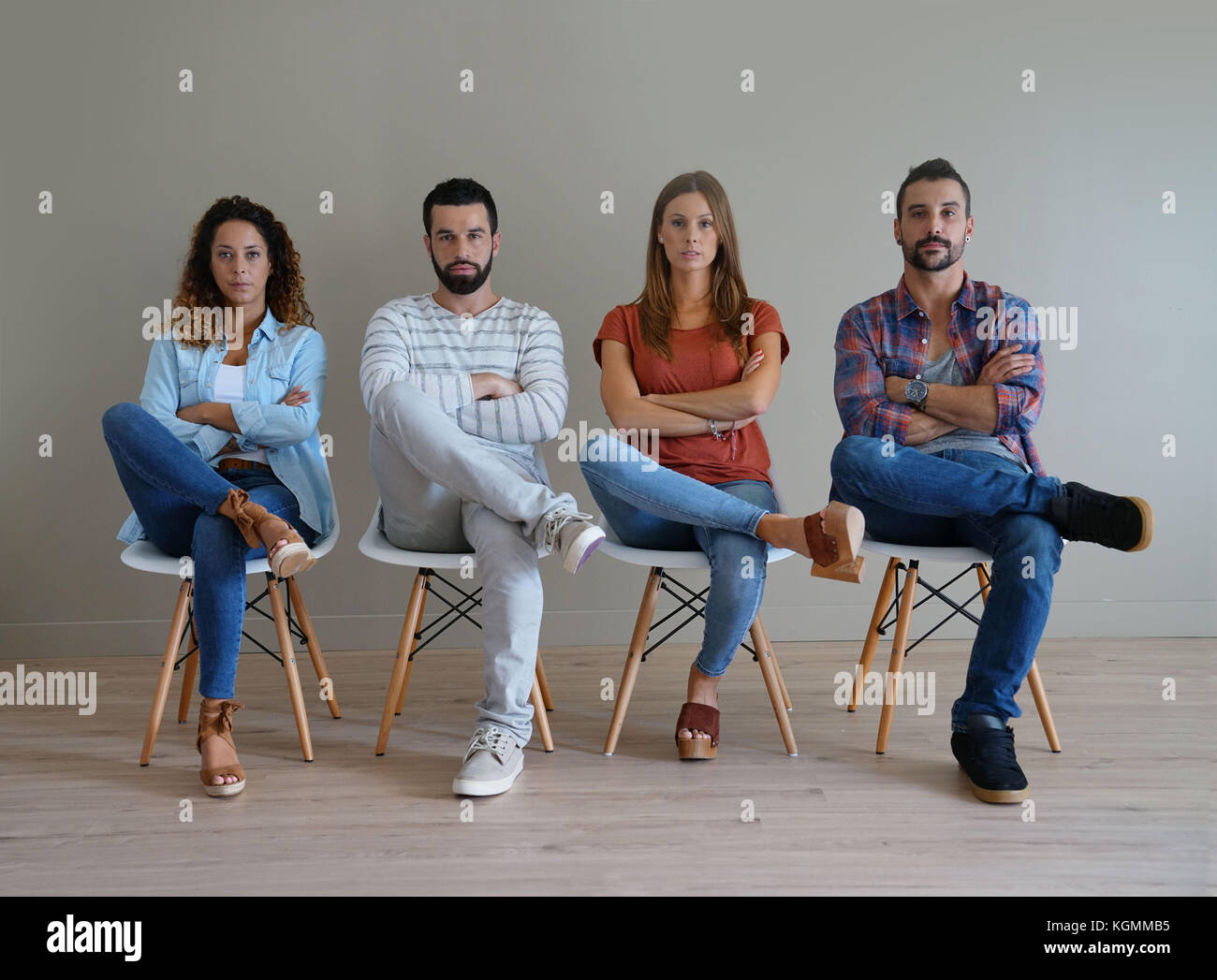 Group of young people sitting on chairs, isolated Stock Photo