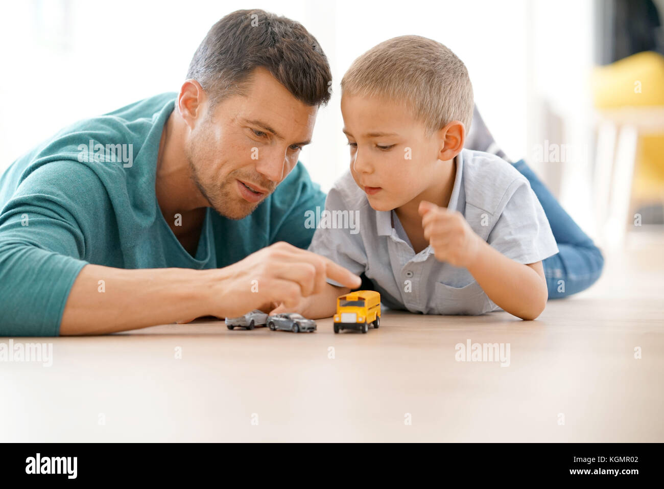 Daddy with son playing with car toys, laying on floor Stock Photo - Alamy