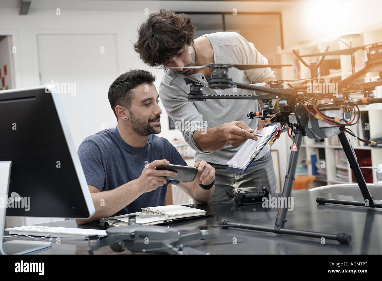 Engineer and technician working together on drone in office Stock Photo ...