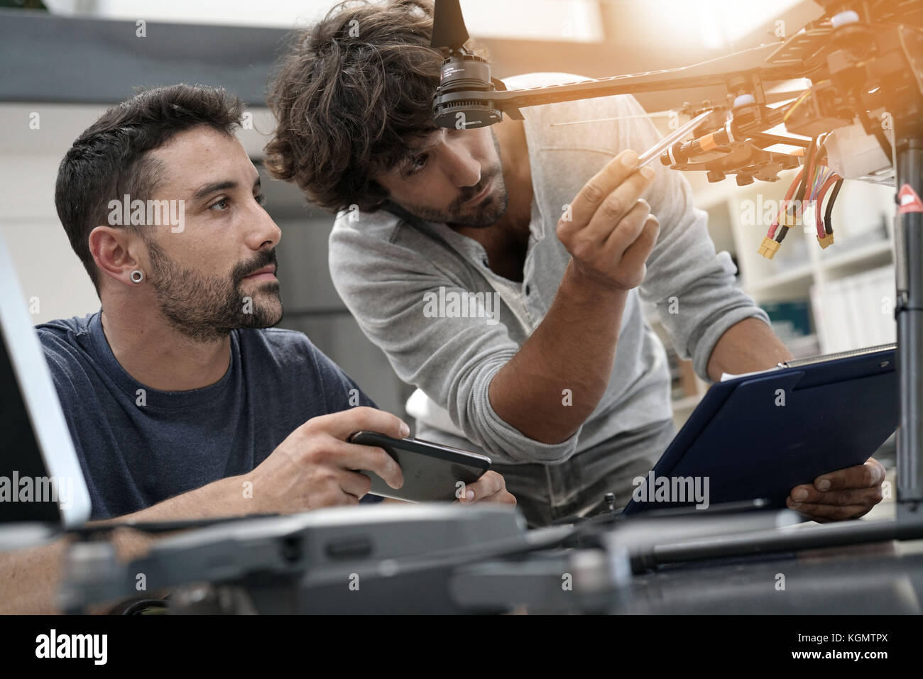 Engineer and technician working together on drone in office Stock Photo ...