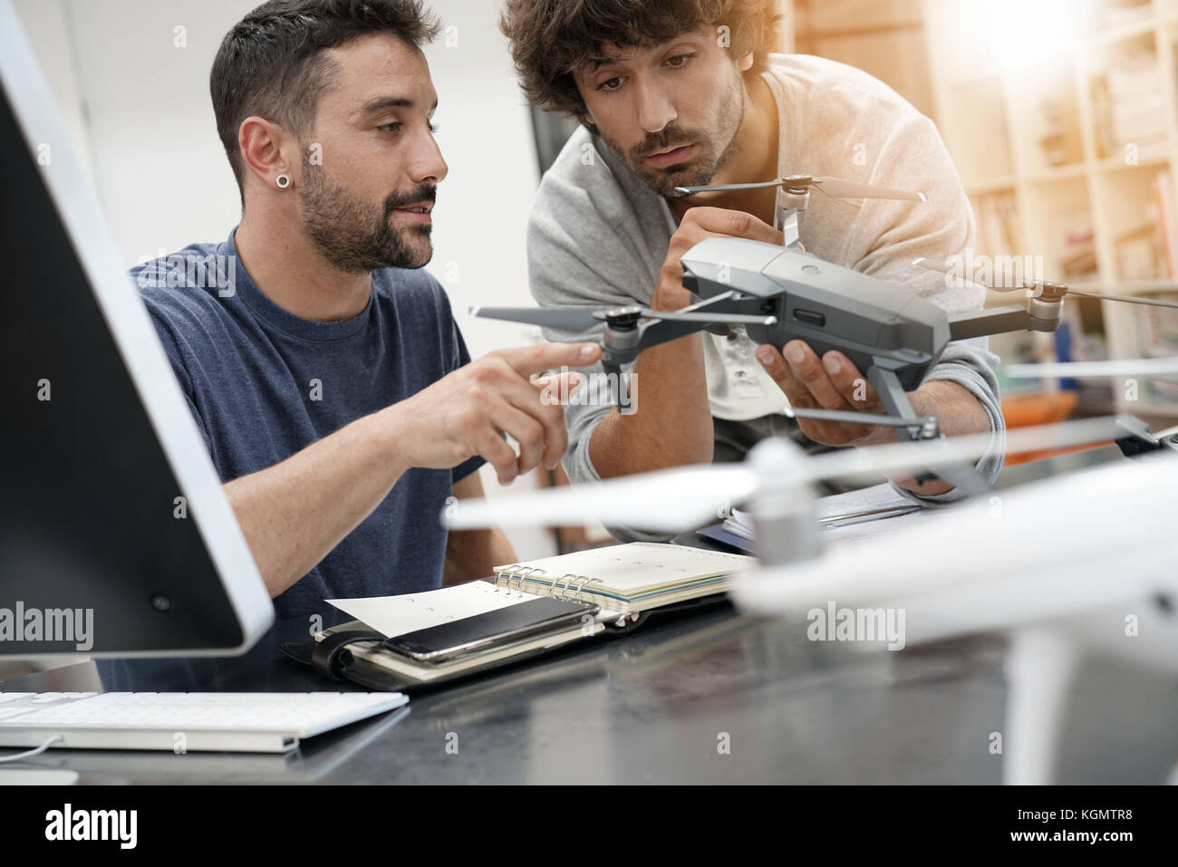 Engineer and technician working together on drone in office Stock Photo ...