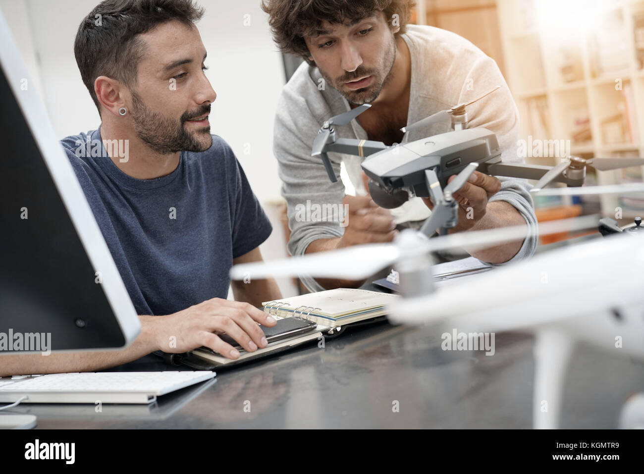 Engineer and technician working together on drone in office Stock Photo ...