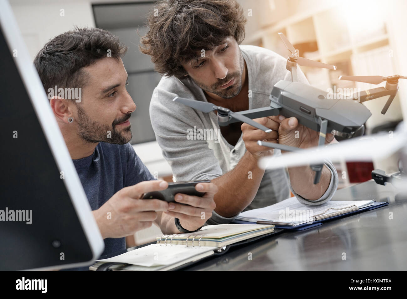 Engineer and technician working together on drone in office Stock Photo ...