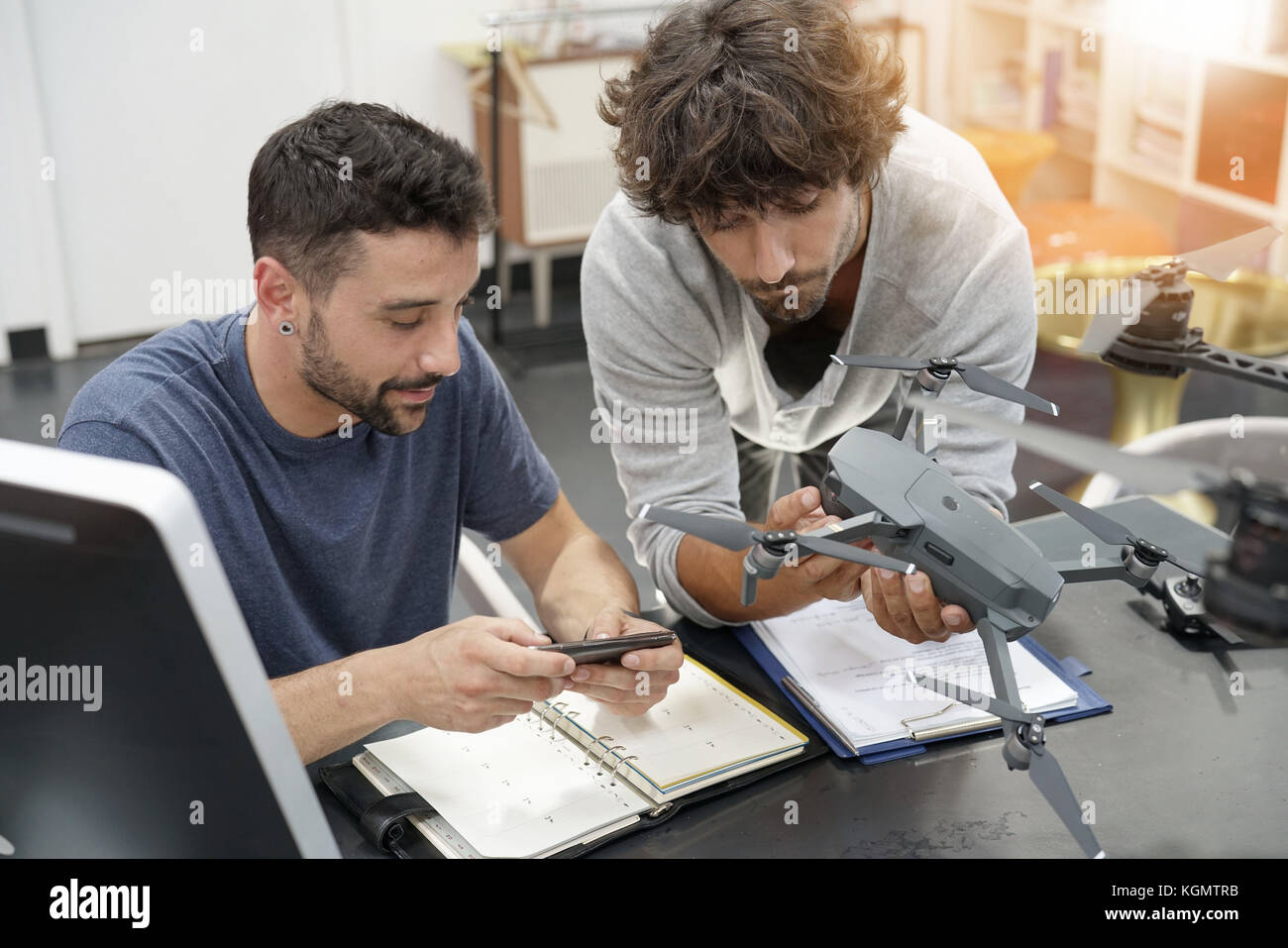 Engineer and technician working together on drone in office Stock Photo ...