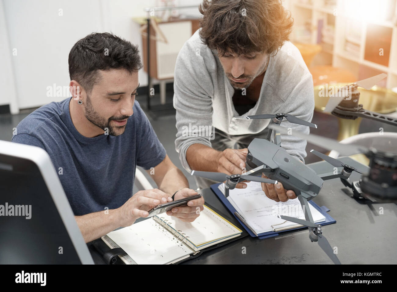 Engineer and technician working together on drone in office Stock Photo ...