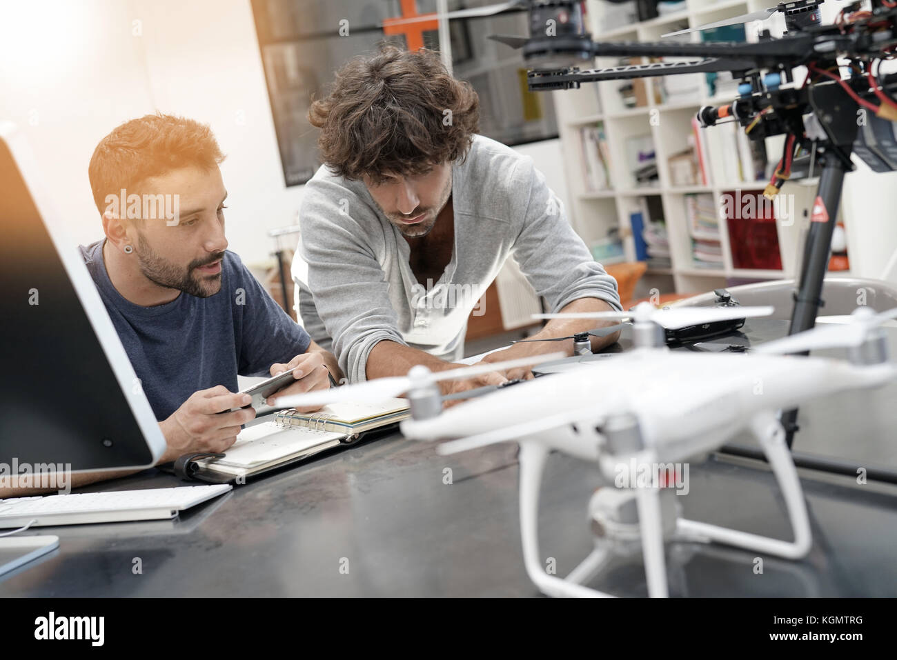 Engineer and technician working together on drone in office Stock Photo ...