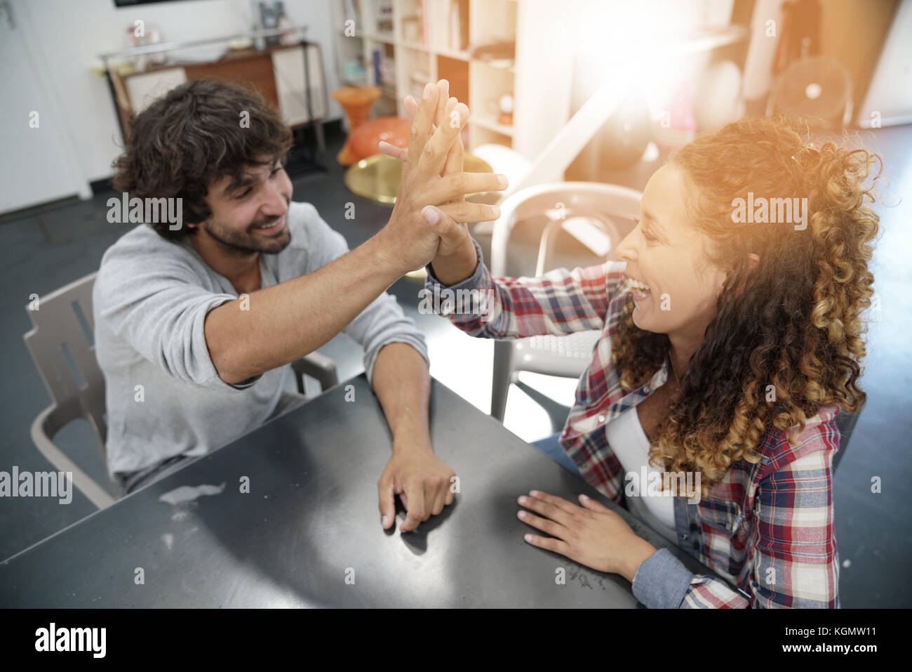 Co-workers  giving one another high five Stock Photo