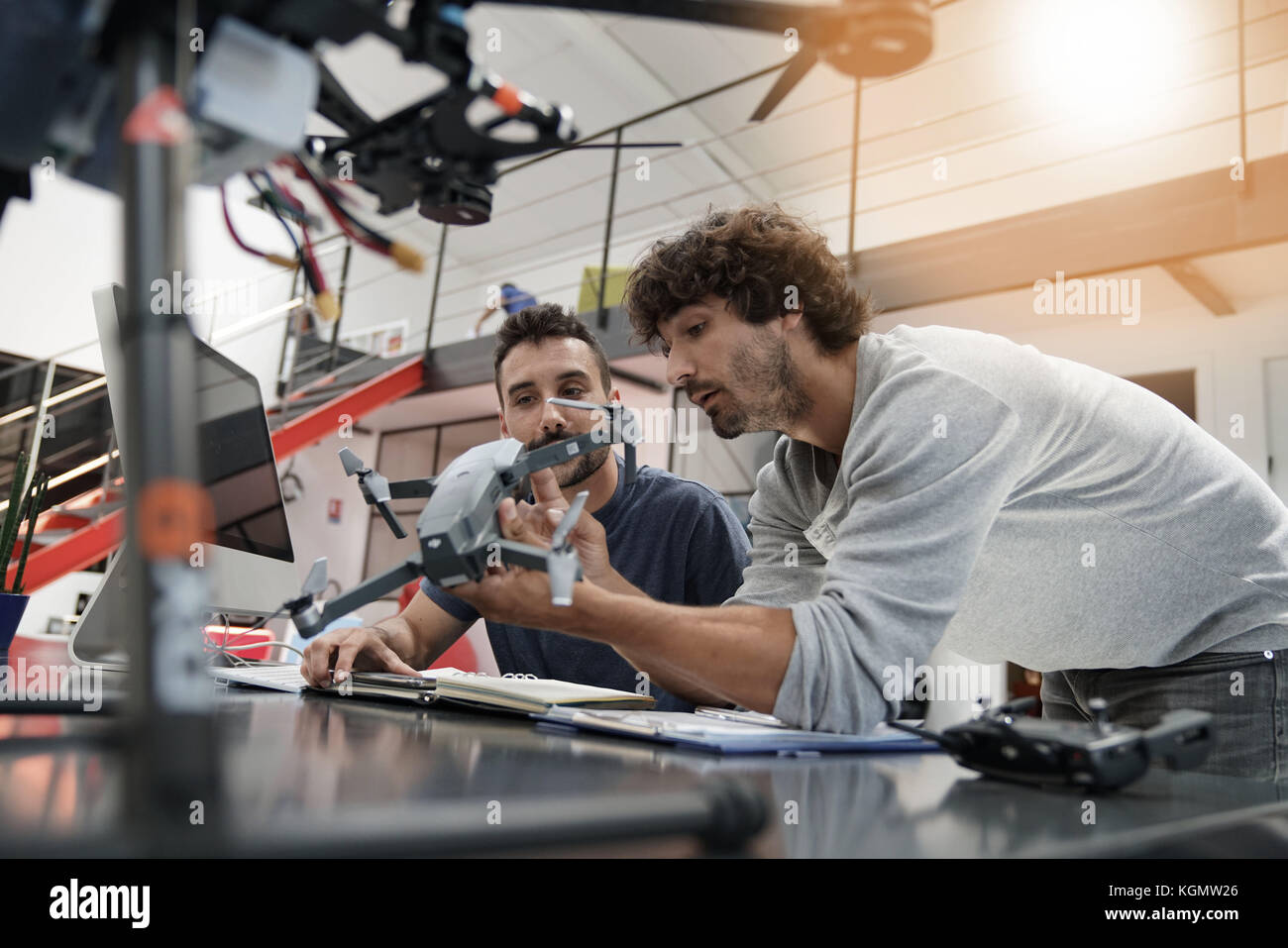 Engineer and technician working together on drone in office Stock Photo ...