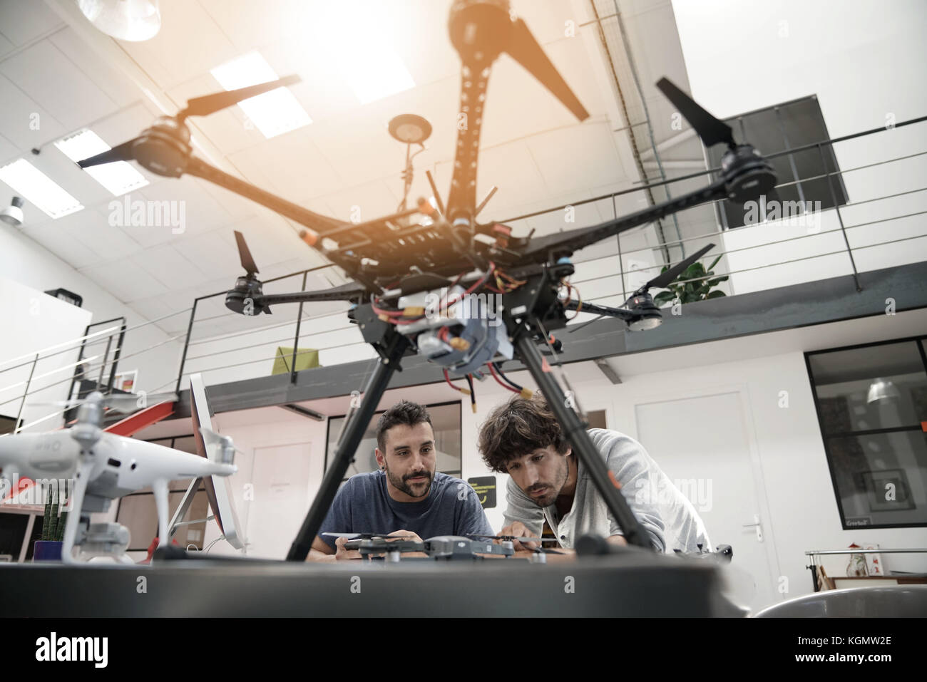 Engineer and technician working together on drone in office Stock Photo ...