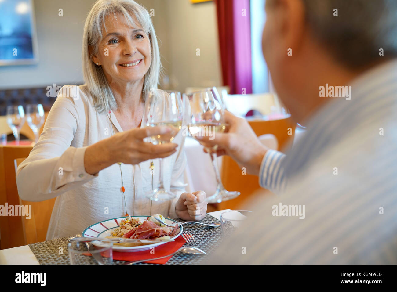 Senior couple having dinner in restaurant, cheering up Stock Photo