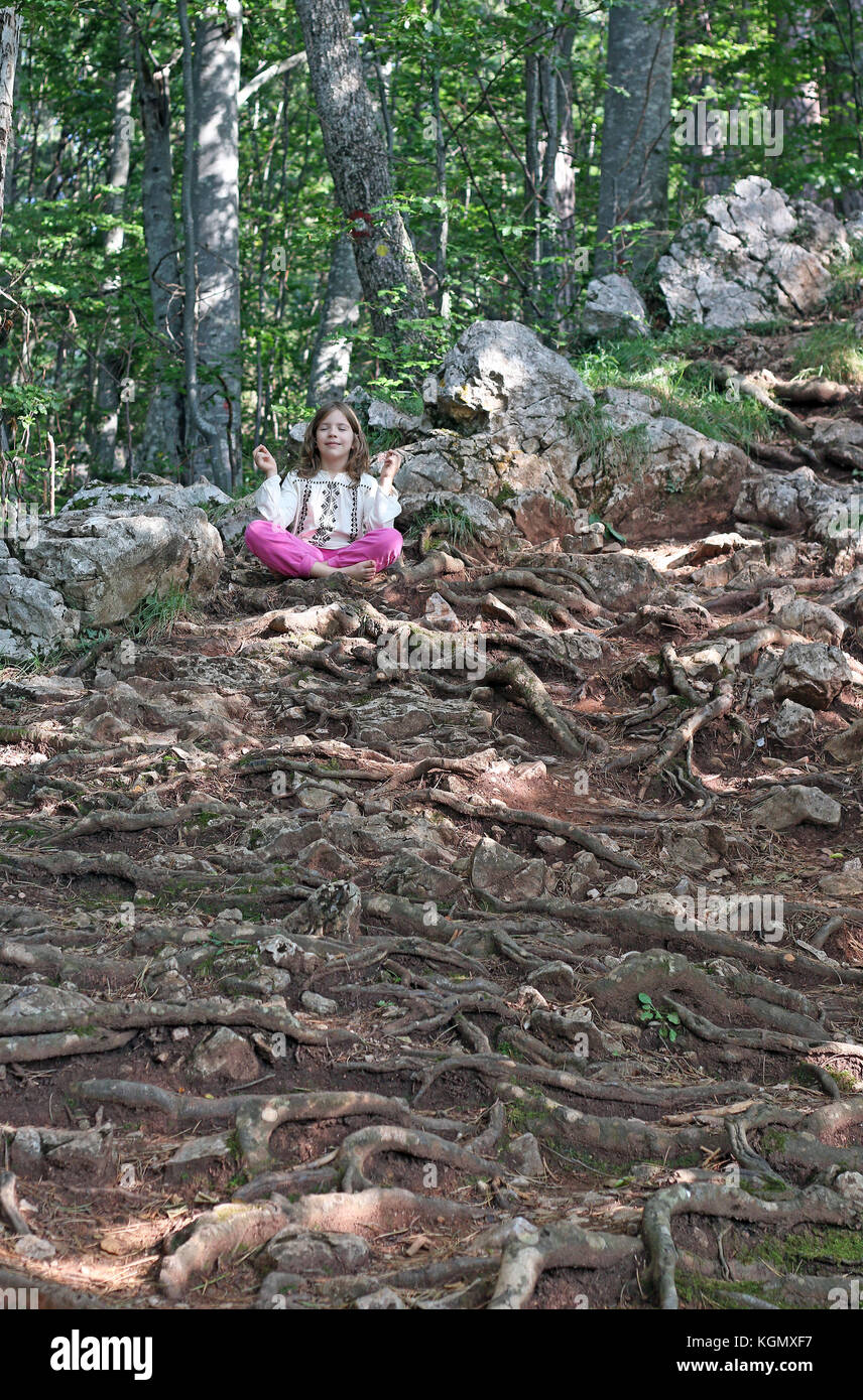 little girl meditating in the forest Stock Photo