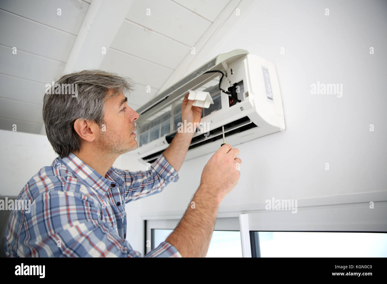 Repairman fixing air conditioner unit Stock Photo Alamy