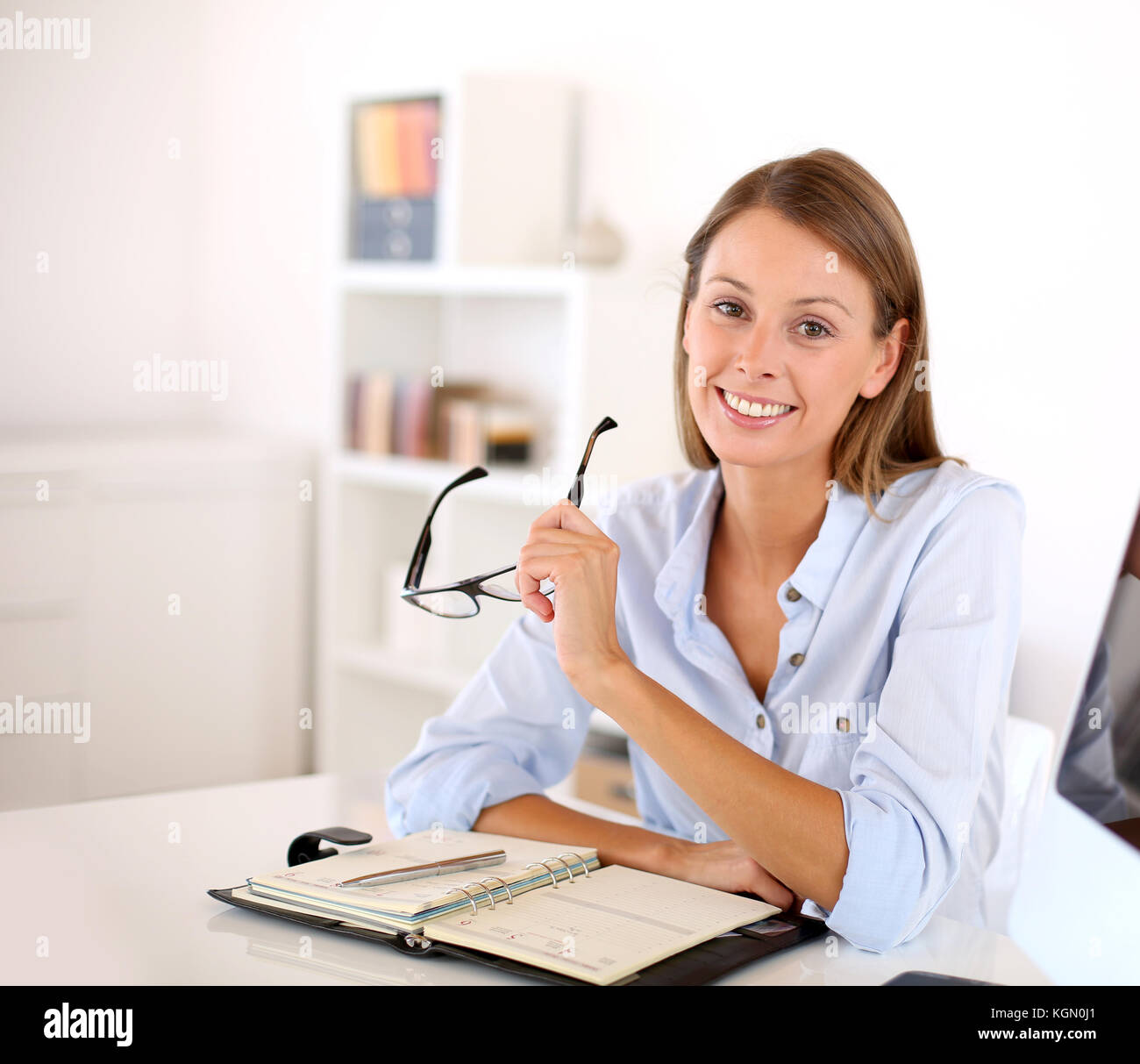 Portrait of smiling woman in office Stock Photo - Alamy