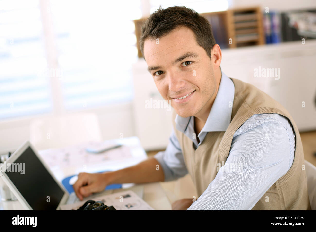 Portrait of smiling man sitting in office Stock Photo - Alamy