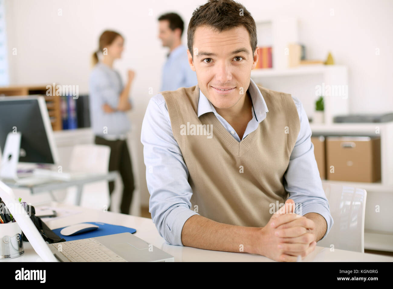 Portrait of smiling man sitting in office Stock Photo - Alamy
