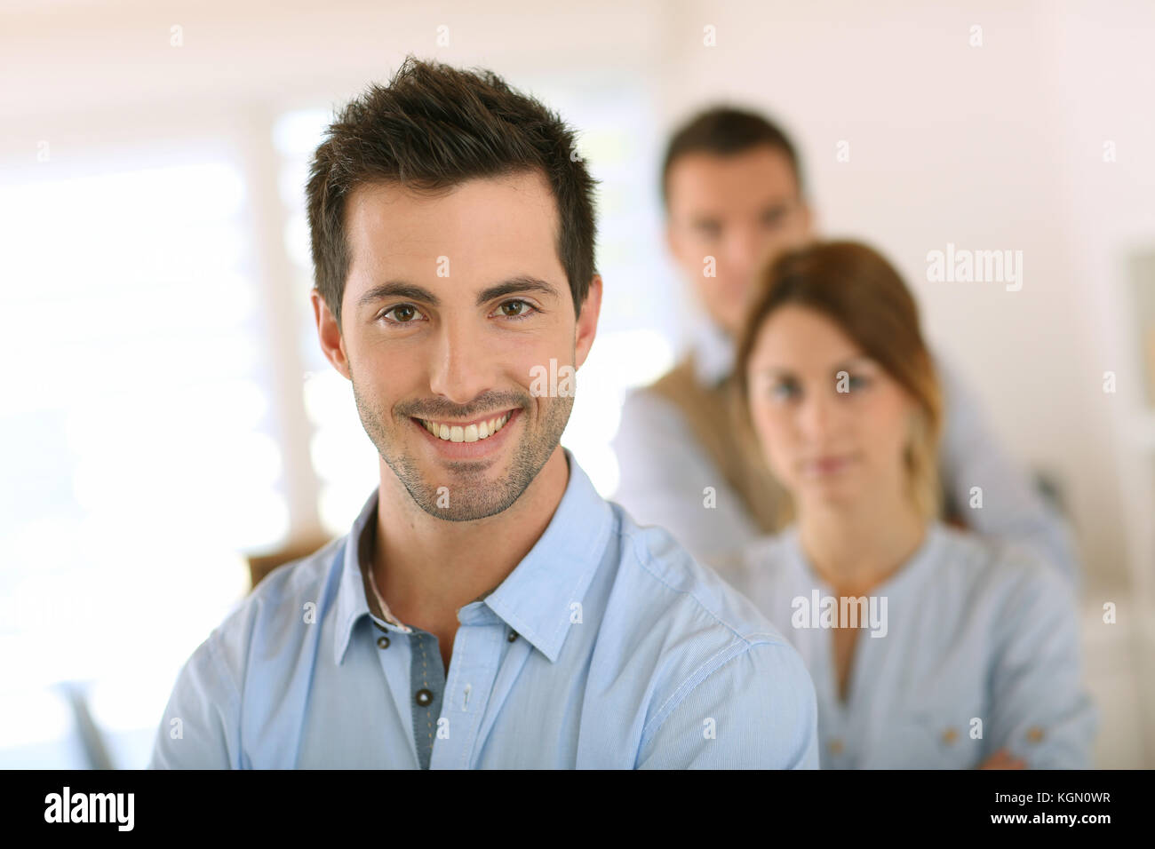 Handsome man standing in front of business team Stock Photo - Alamy