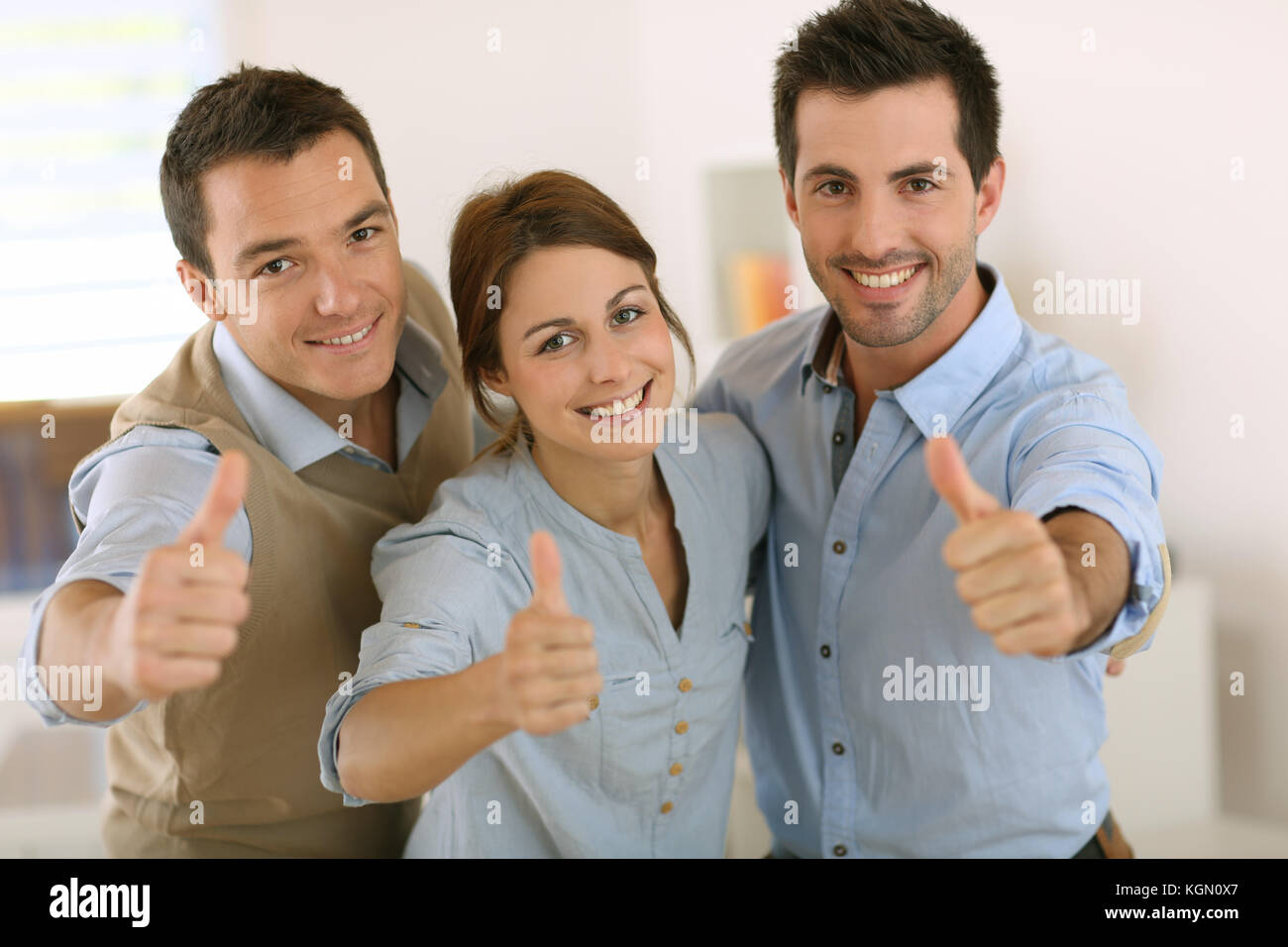 Portrait of cheerful business team showing thumbs up Stock Photo - Alamy