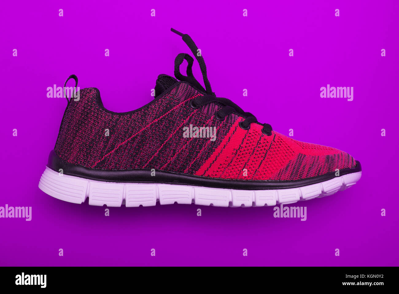 Red and black sport woman shoes isolated on purple background Stock Photo