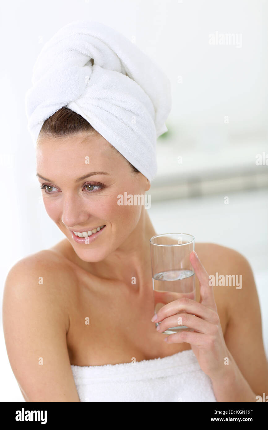 Attractive woman in bathroom drinking water Stock Photo Alamy