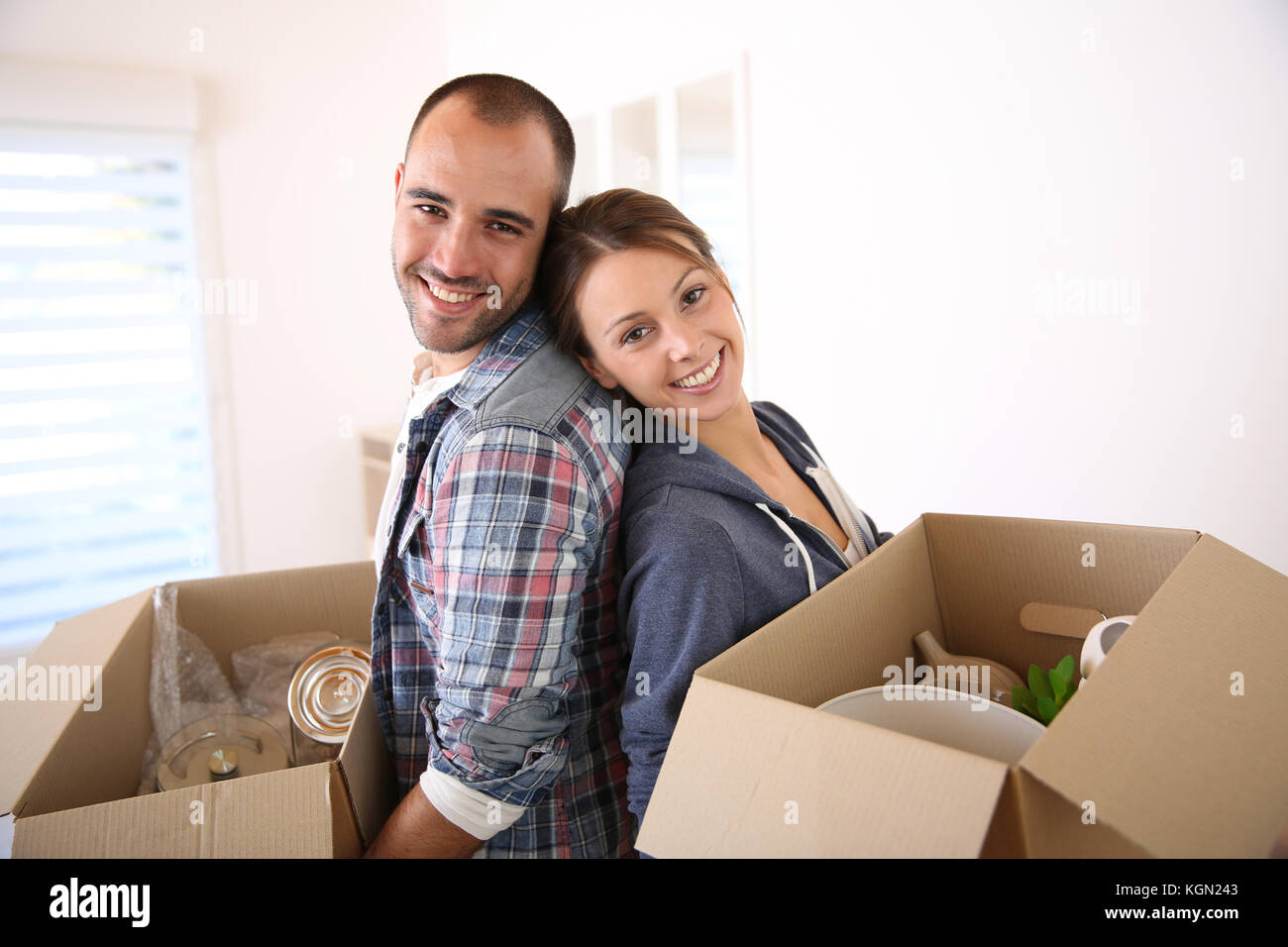 Cheerful young adults packing their stuff in cardboards Stock Photo - Alamy