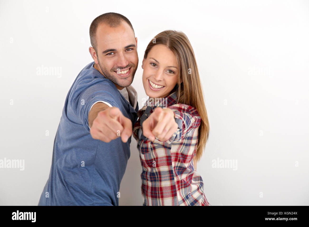 Trendy couple on white background pointing at camera Stock Photo - Alamy