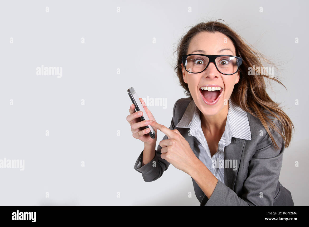 Business girl with funny look showing smartphone Stock Photo - Alamy
