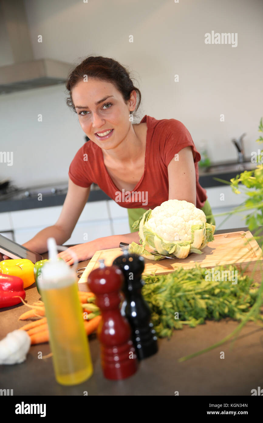 Woman in kitchen looking at recipe on tablet Stock Photo