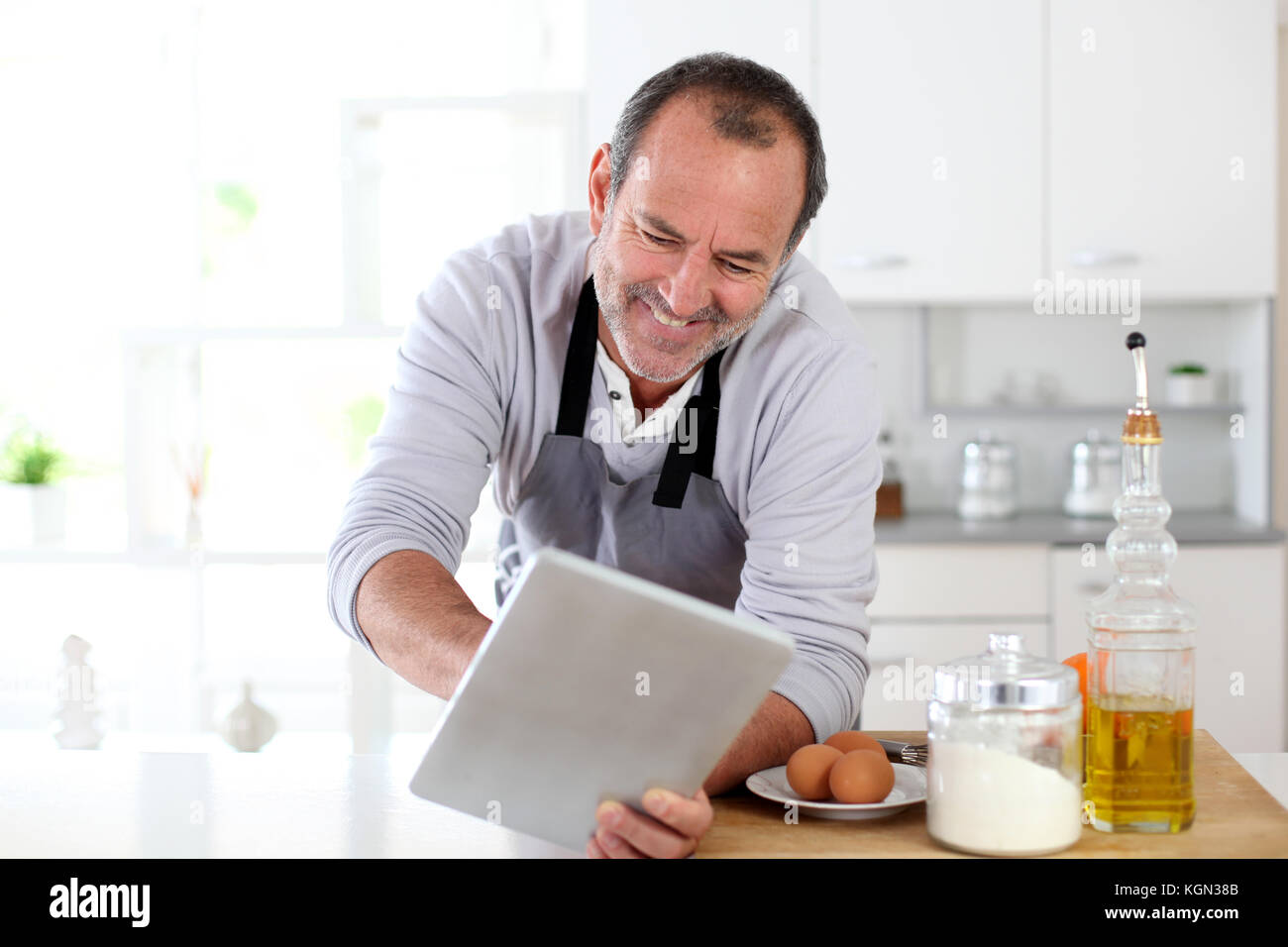 Man Using Kitchen Machine Senior man in kitchen using electronic tablet Stock Photo - Alamy