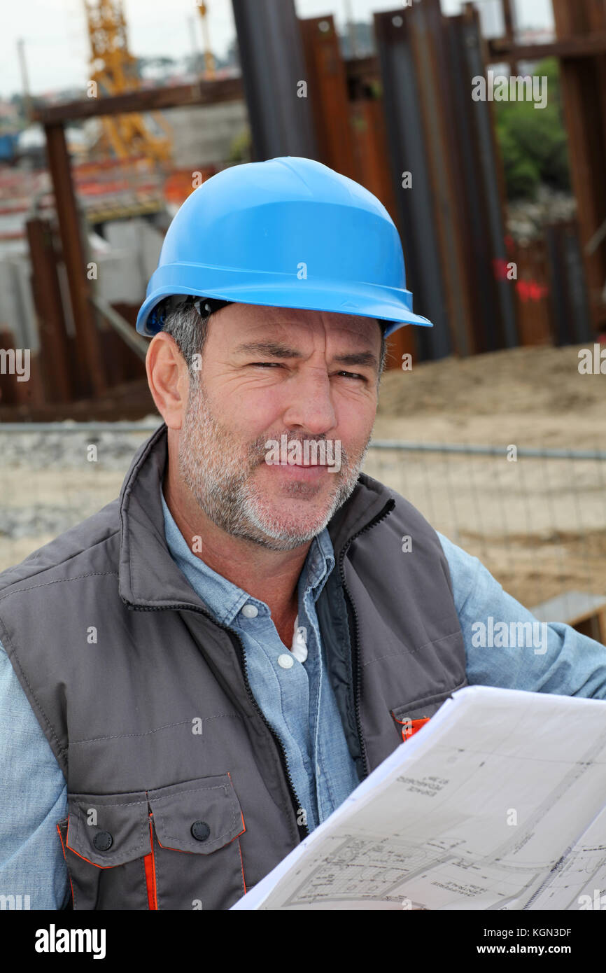 Construction manager controlling building site with plan Stock Photo