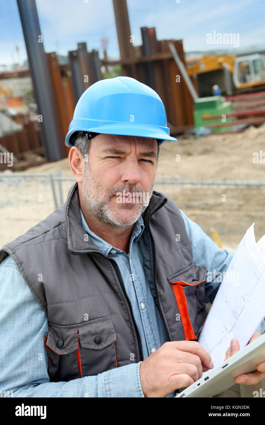 Construction manager controlling building site with plan Stock Photo