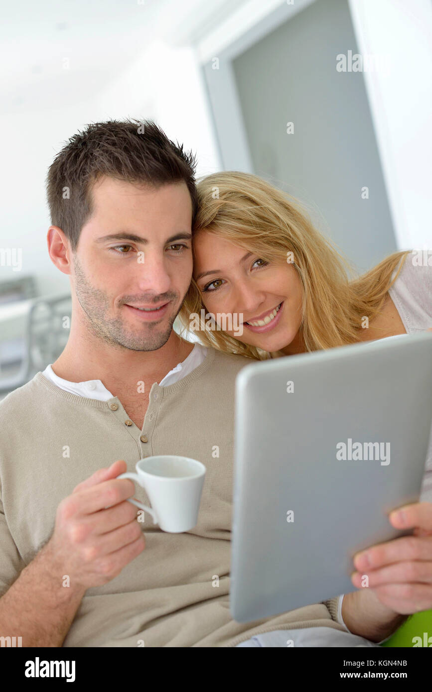 Cheerful couple using digital tablet at home Stock Photo - Alamy
