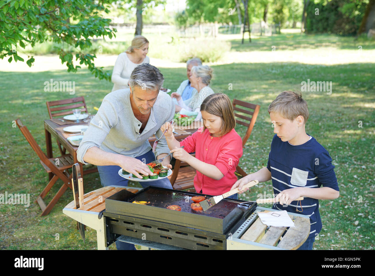 Man With Kids Cooking Barbecue For The Family Stock Photo Alamy