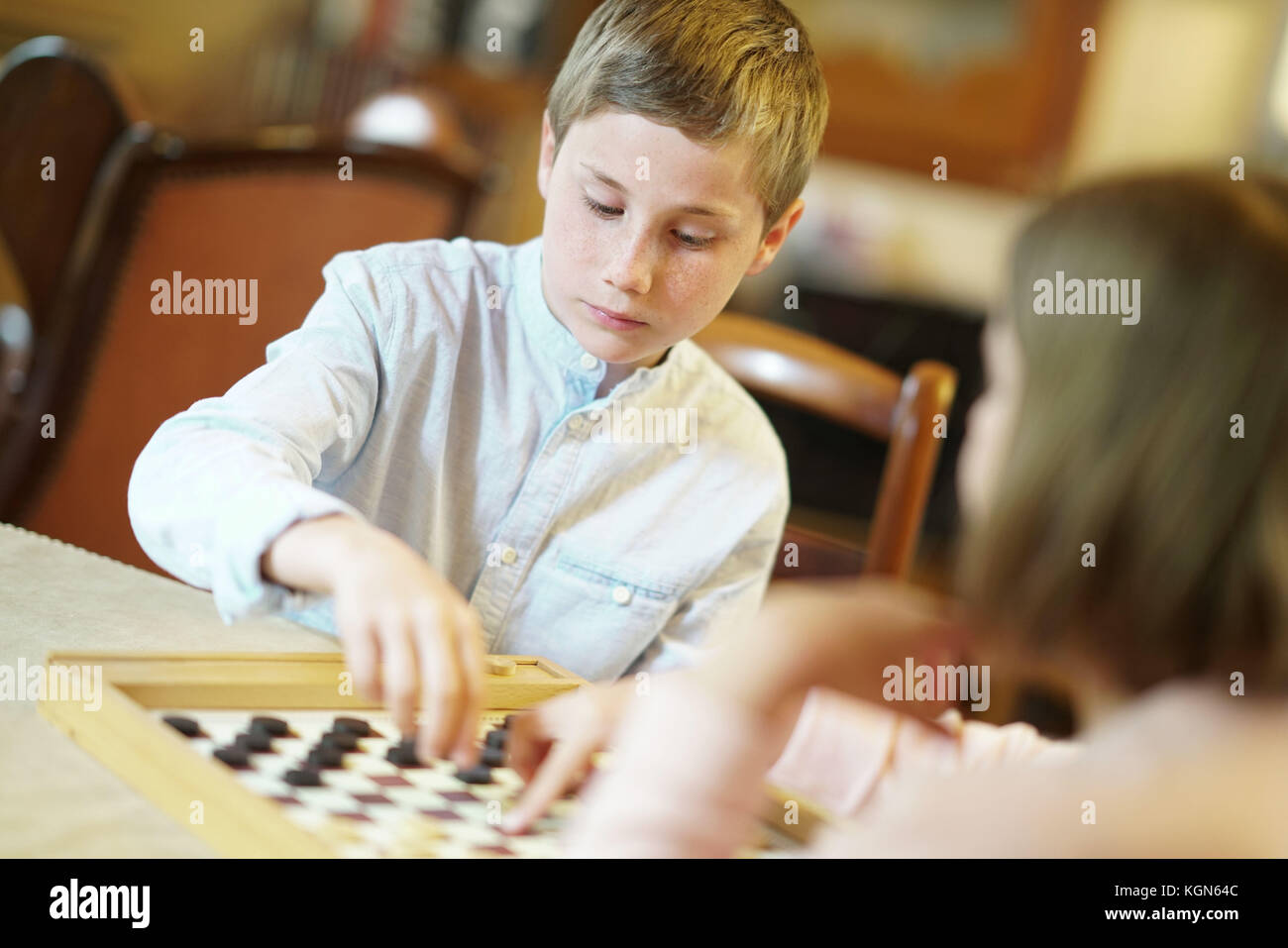 Kids playing checkers at home Stock Photo