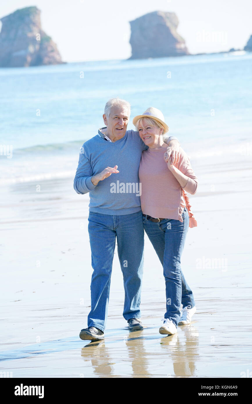 Senior couple walking on the beach Stock Photo - Alamy
