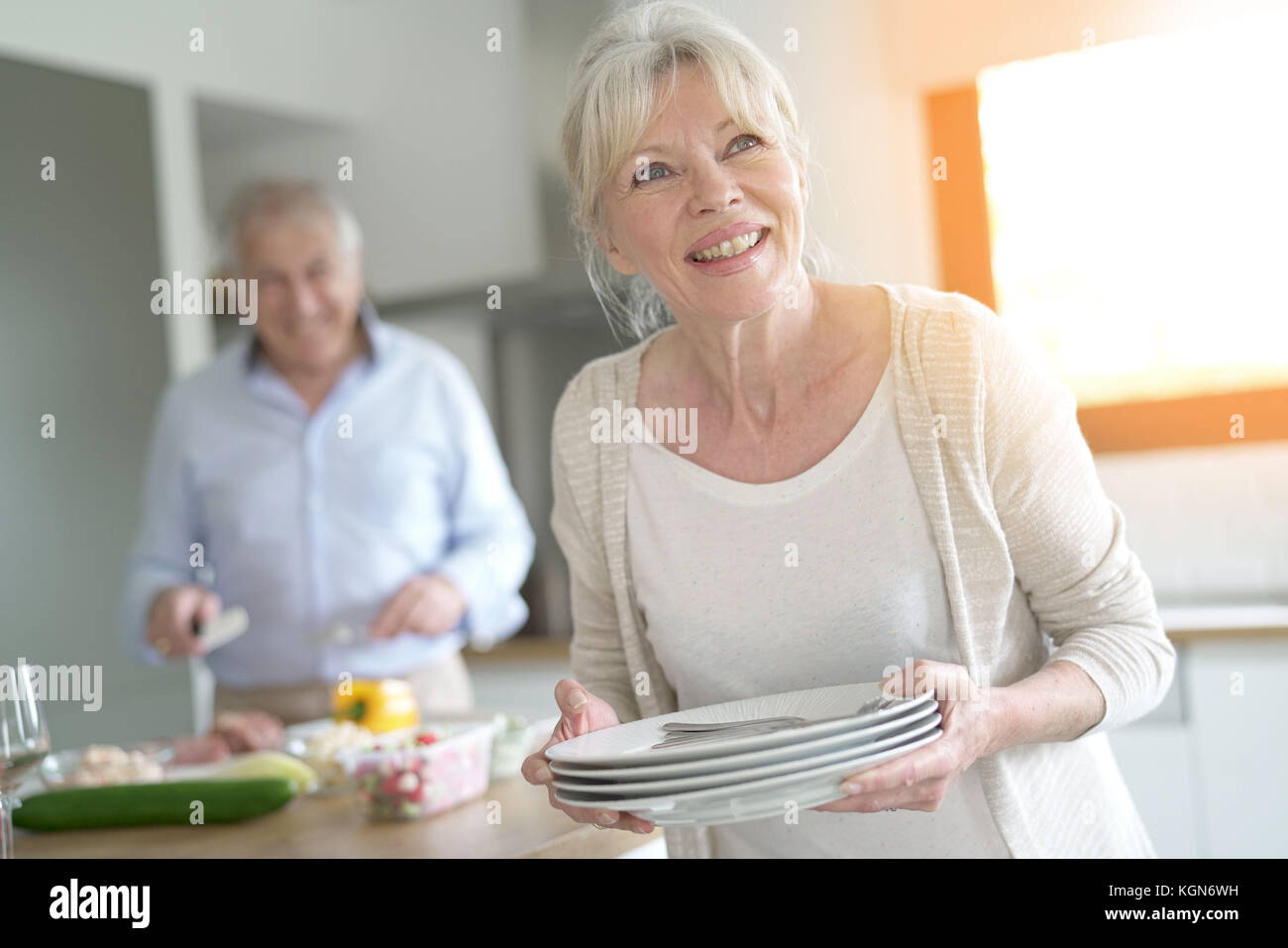 Senior woman laying the table for lunch Stock Photo