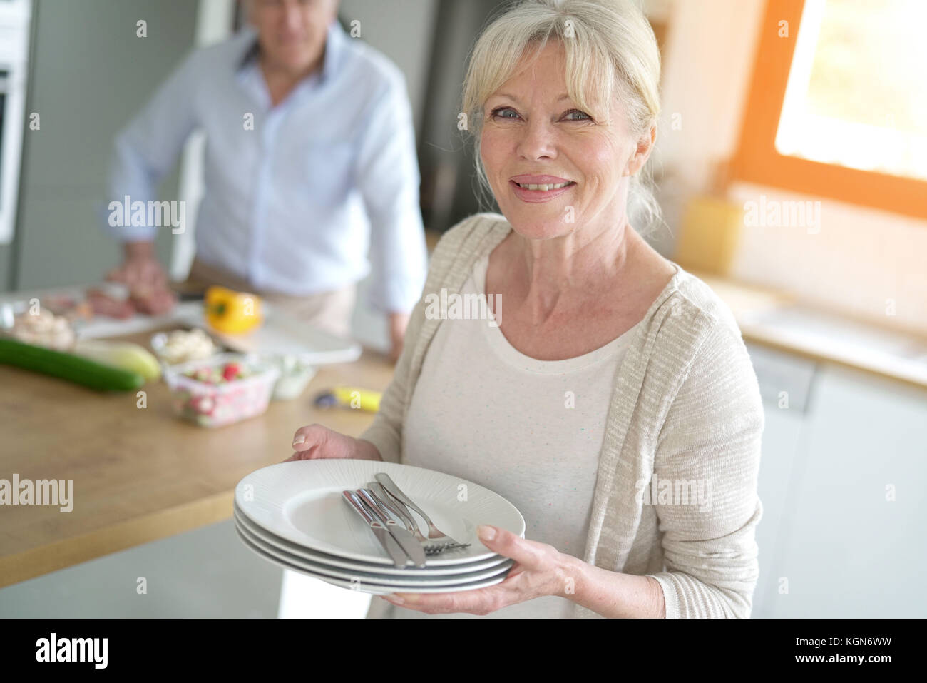 Senior woman laying the table for lunch Stock Photo