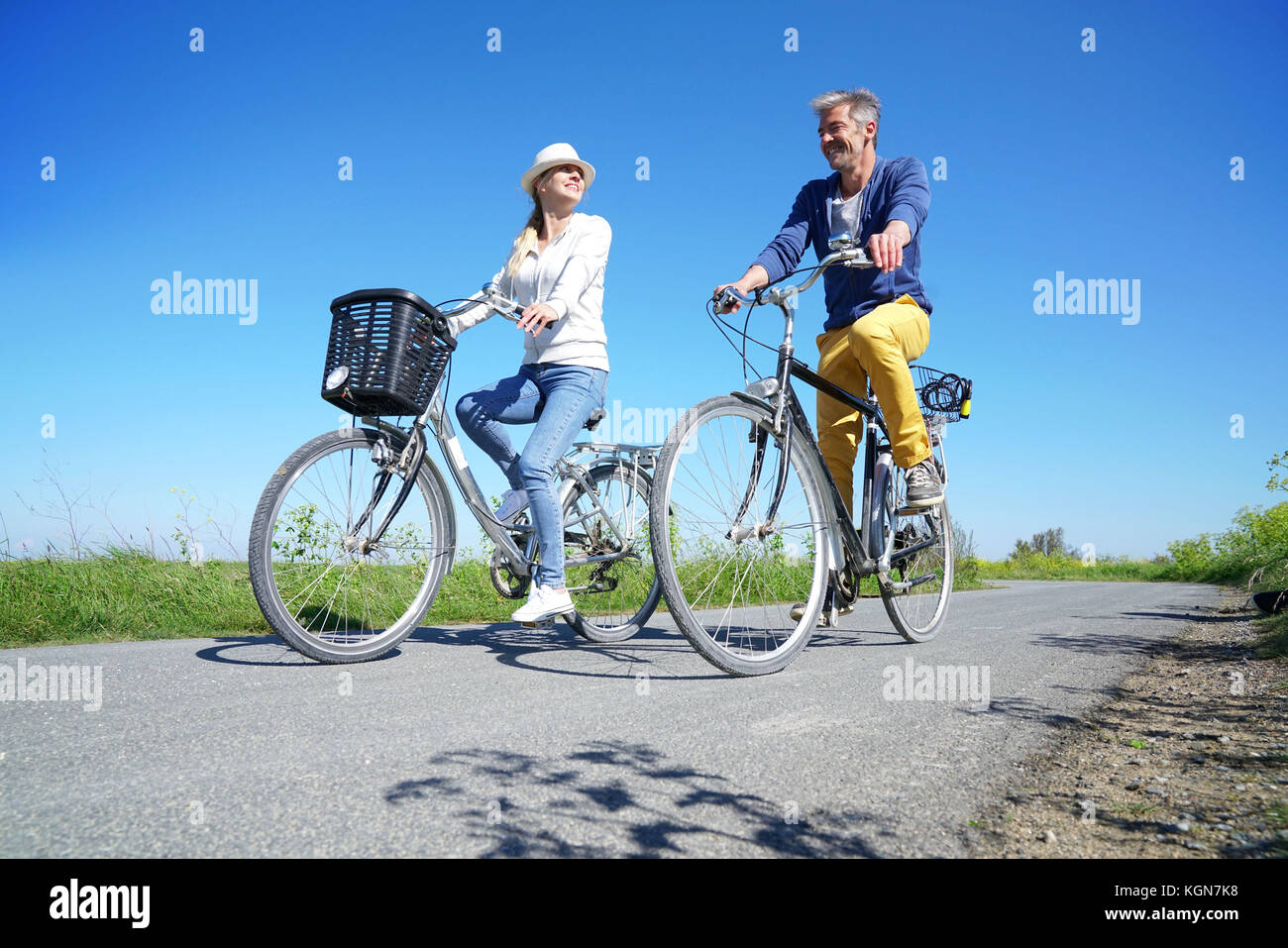 Cheerful couple riding bike on a sunny day Stock Photo
