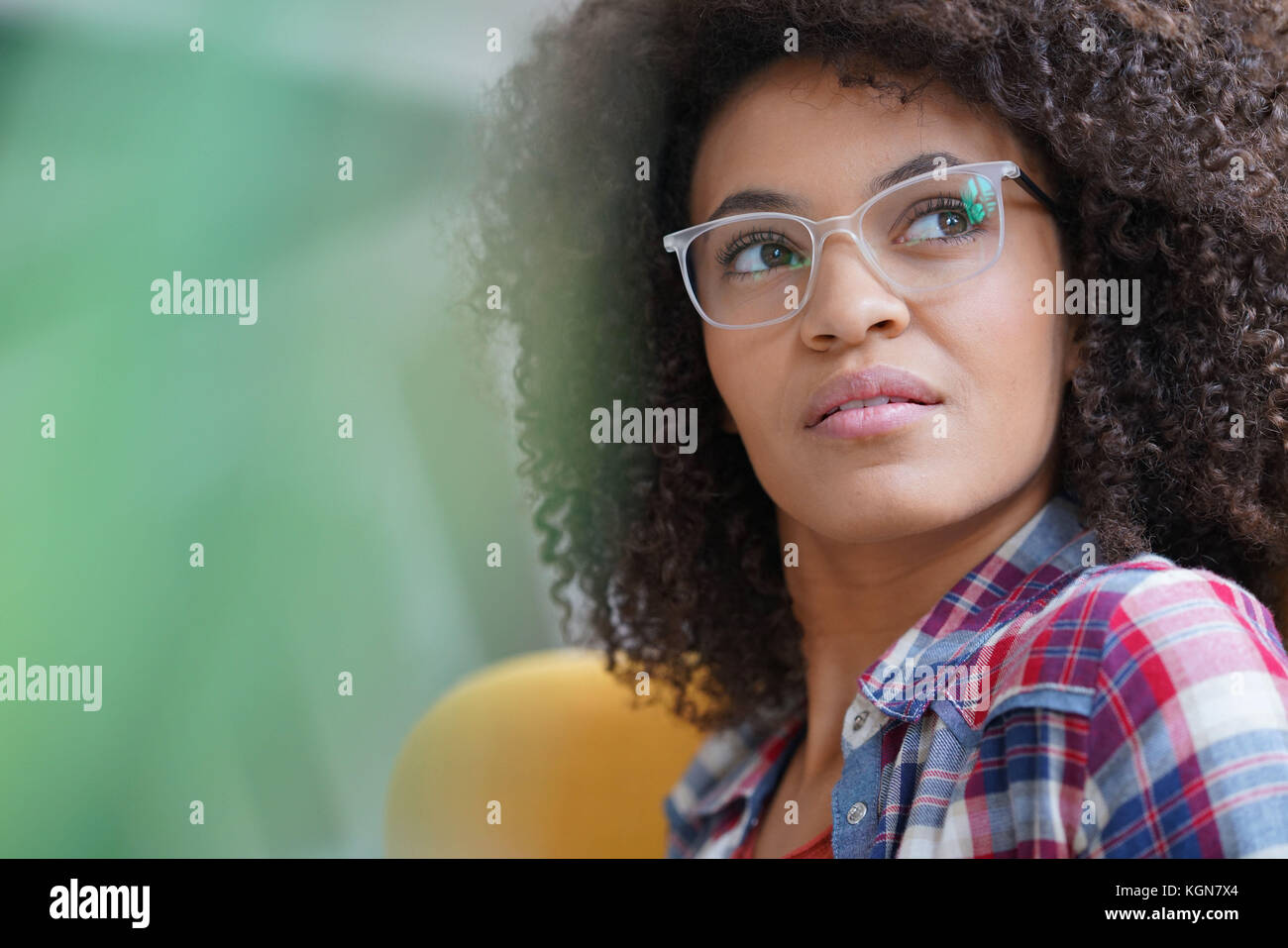 Attractive Mixed Race Woman With Eyeglasses Relaxing In Armchair