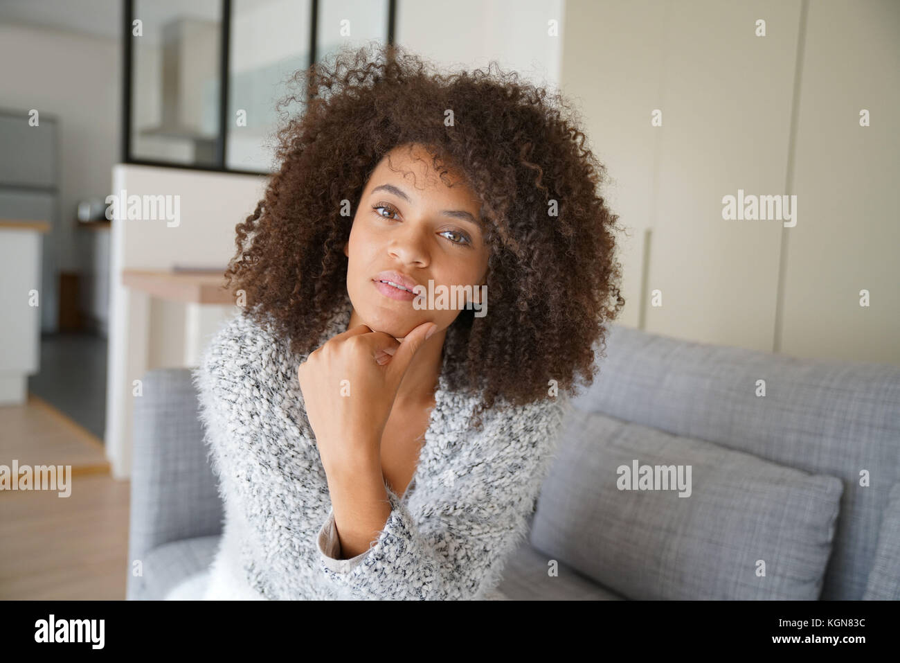 Attractive mixed-race woman relaxing on sofa Stock Photo