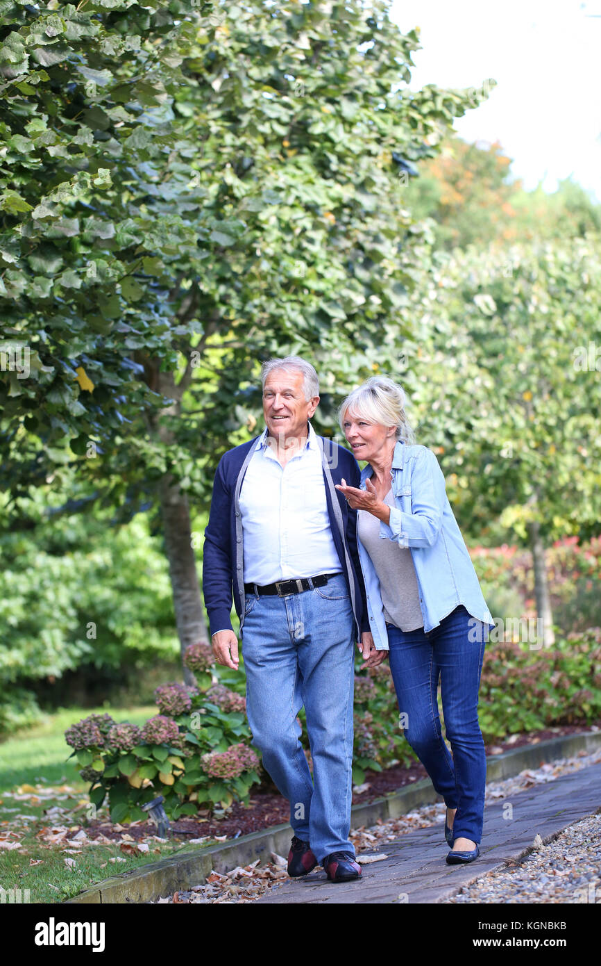 Senior couple walking together in park Stock Photo - Alamy