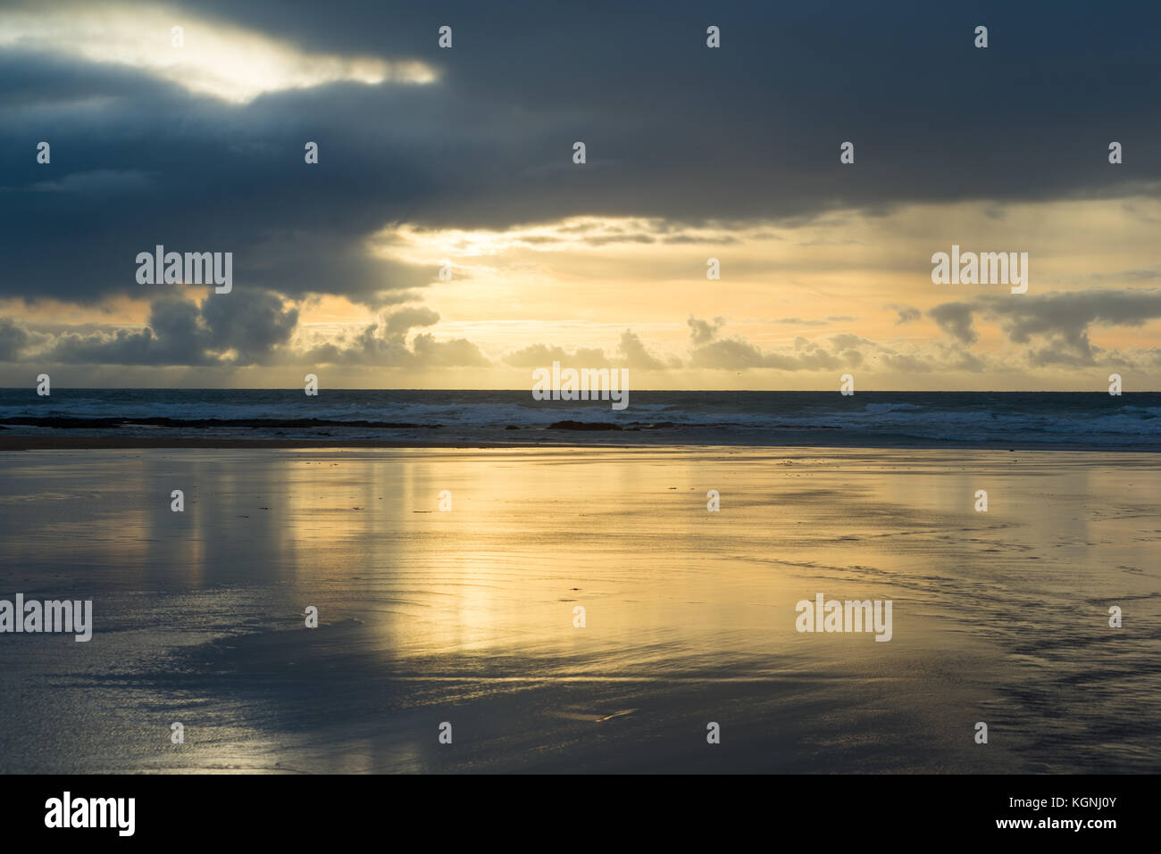 Beautiful and dramatic golden Cornish sunset at Constantine Bay, St Merryn, Cornwall, 9th November, 2017 with reflection in wet sand, UK Stock Photo