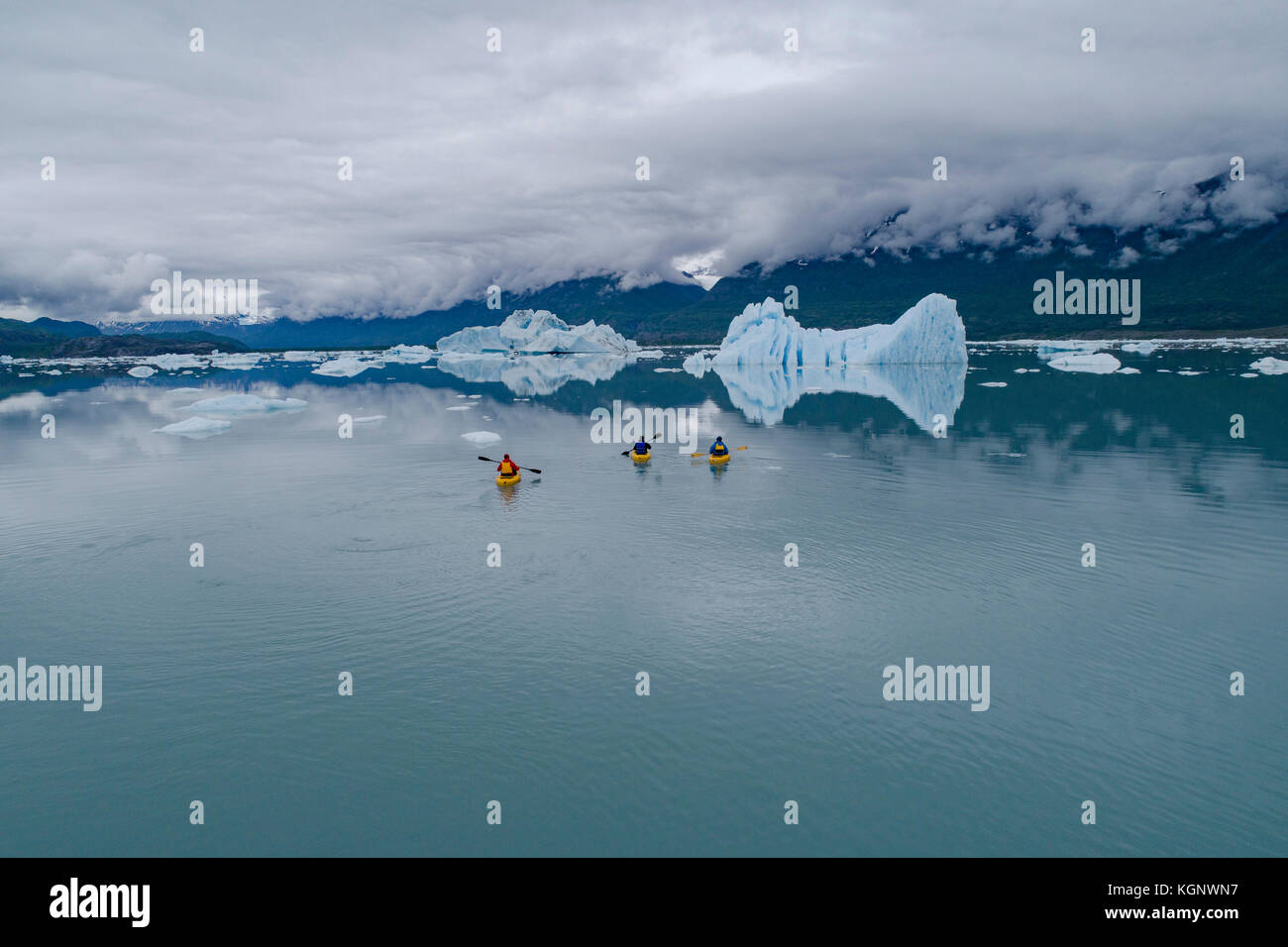 People canoeing in glacier lagoon against cloudy sky, Knik Glacier, Palmer, Alaska, USA Stock Photo