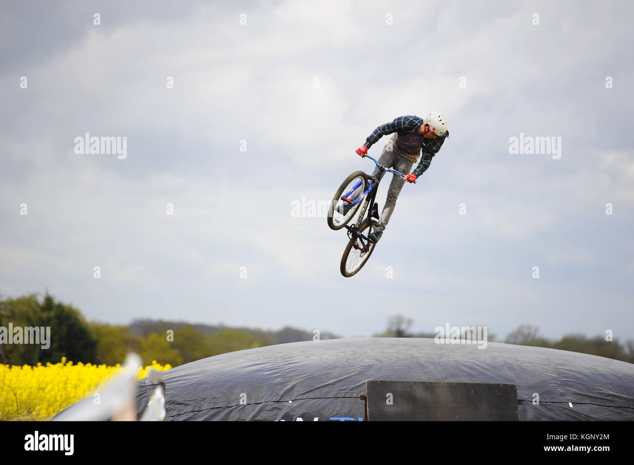Mountain biking at Chicksands, Bedfordshire. Riders jumping off a large take off ramp onto a huge airbag. Trying & perfecting new tricks. Stock Photo