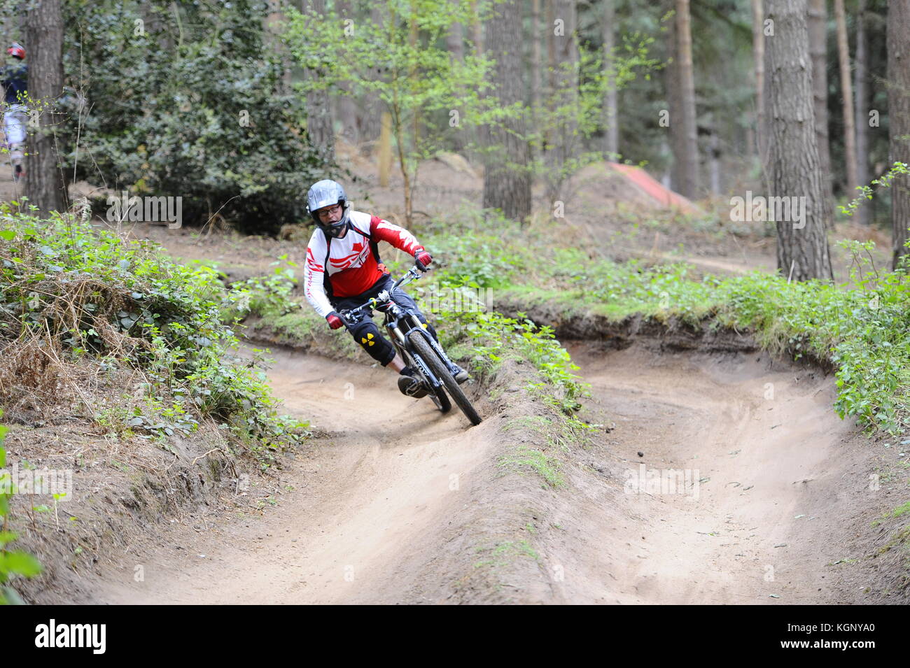 Mountain biking at Chicksands, Bedfordshire. Riders descending down a steep track littered with jumps and berms. Stock Photo