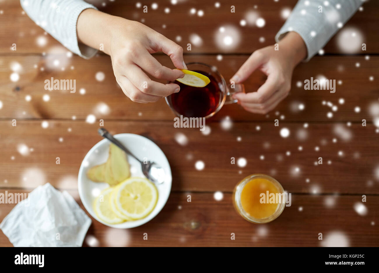 Close up of ill woman adding lemon to tea cup stock photo alamy