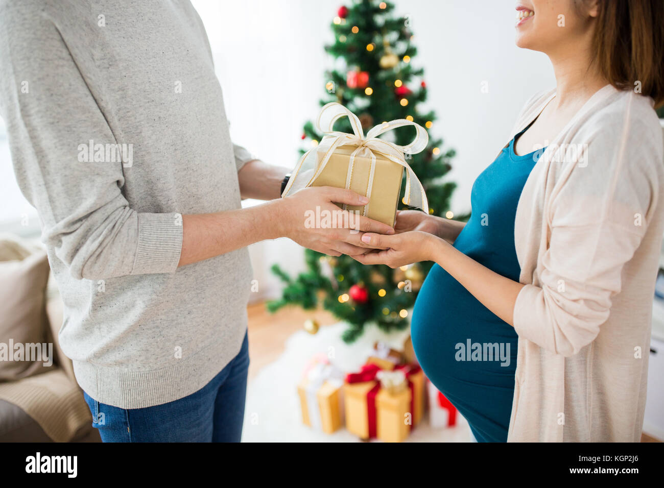 husband giving christmas present to pregnant wife Stock Photo - Alamy